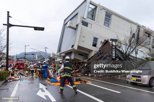 Firefighters escape from a collapsed building during a strong aftershock on January 03, 2024 in Wajima, Japan. A series of major earthquakes have...