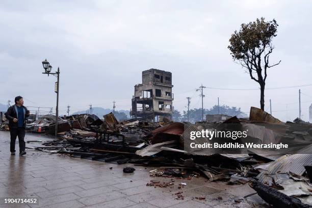 Man walks near many buildings destroyed by fire after earthquakes struck, on January 03, 2024 in Wajima, Japan. A series of major earthquakes have...