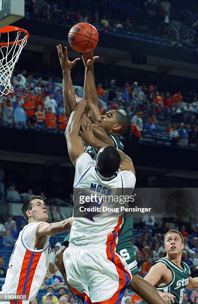 Alan Anderson of the Michigan State Spartans goes up for a shot and is fouled by Adrian Moss of the University of Florida Gators as the Spartans...