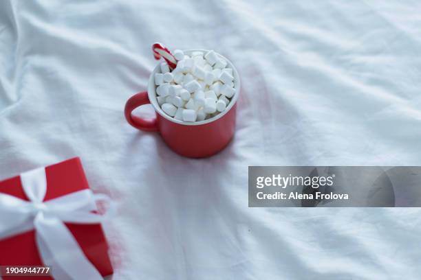 christmas present and mug with cacao  on white bed - big country breakfast stock-fotos und bilder