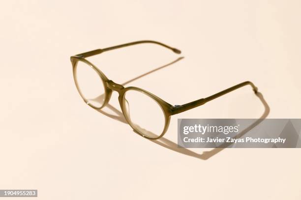 modern eyeglasses on brown pastel background - lunettes de vue photos et images de collection