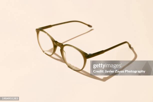 modern eyeglasses on brown pastel background - olhos castanho claros - fotografias e filmes do acervo