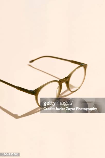 modern eyeglasses on brown pastel background - olhos castanho claros - fotografias e filmes do acervo