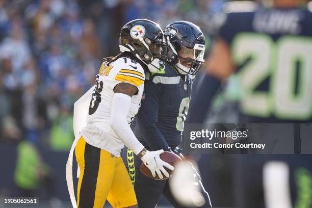 Diontae Johnson of the Pittsburgh Steelers and Devin Bush of the Seattle Seahawks talk after a play at Lumen Field on December 31, 2023 in Seattle,...