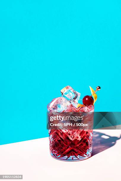 close-up of drink in glass against blue background - gin tasting stock pictures, royalty-free photos & images