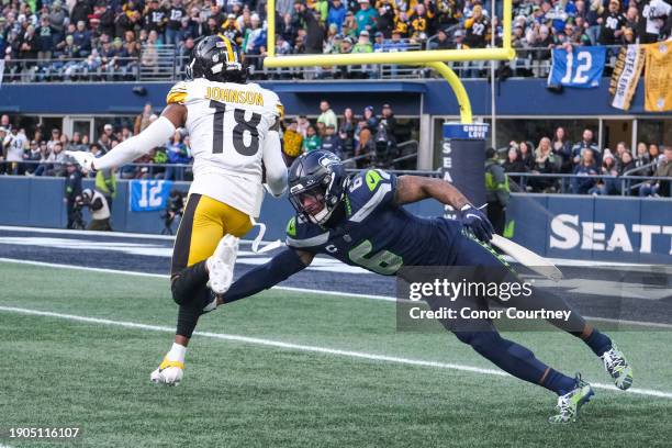 Quandre Diggs of the Seattle Seahawks tries to tackle Diontae Johnson of the Pittsburgh Steelers at Lumen Field on December 31, 2023 in Seattle,...