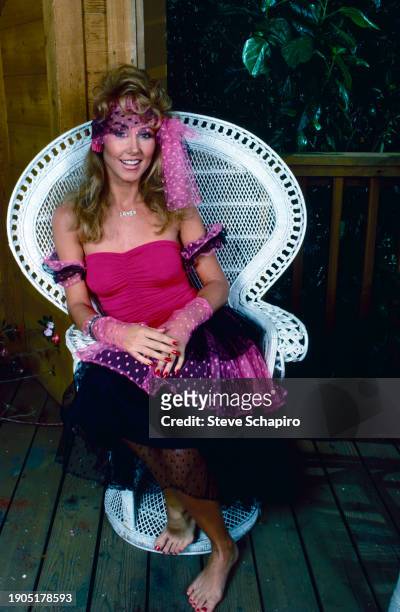 Portrait of American model & actress Linda Thompson Jenner as she sits in a wicker chair, Los Angeles, California, 1983.