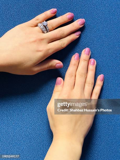 female hands with blue background - pink nail polish stock pictures, royalty-free photos & images