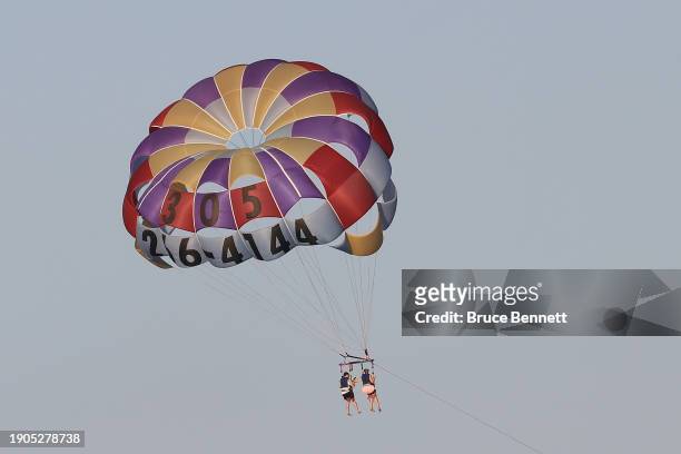 Visitors parasail over South Beach on January 01, 2024 in Miami Beach, Florida, United States. The warm climate and the beautiful beaches draws...