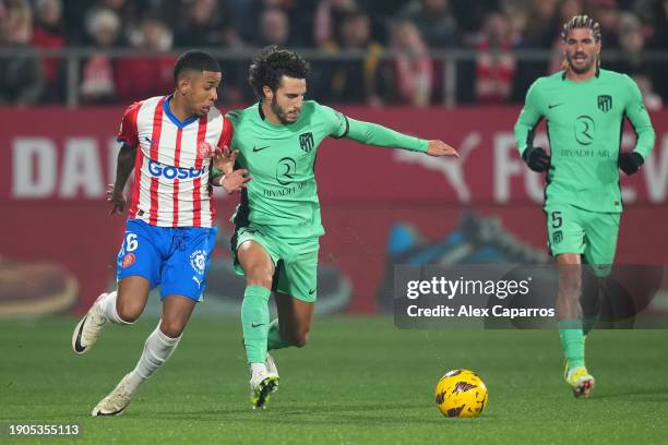 Savio of Girona FC battles for possession with Mario Hermoso of Atletico Madrid during the LaLiga EA Sports match between Girona FC and Atletico...