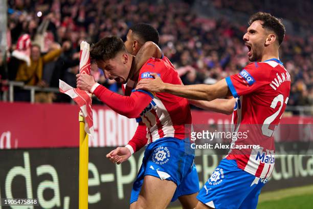 Valery Fernandez of Girona FC celebrates with teammate Savio Moreira and Ivan Martin after scoring their team's first goal during the LaLiga EA...
