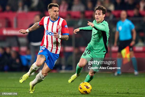 Aleix Garcia of Girona FC is challenged by Rodrigo Riquelme of Atletico de Madrid during the LaLiga EA Sports match between Girona FC and Atletico de...