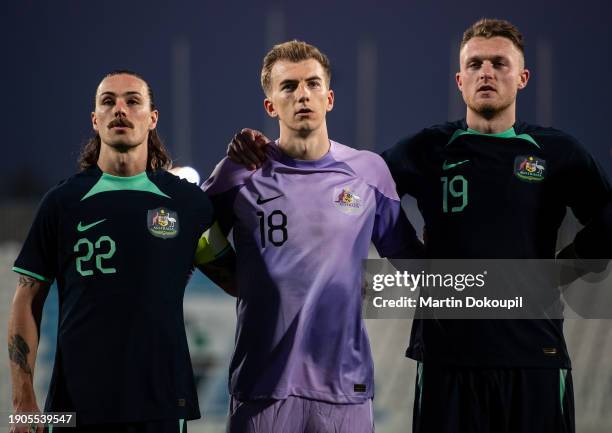 Australia's captain Jackson Alexander Irvine , goalkeeper Joe Anthony Gauci and Harry James Souttar sing the national anthem ahead of the...