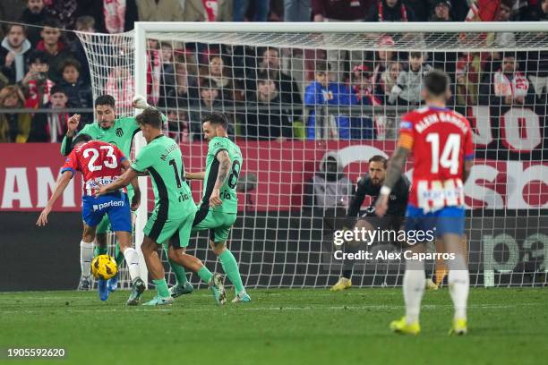 Ivan Martin of Girona FC scores their team's fourth goal under pressure from Marcos Llorente and Saul Niguez of Atletico Madrid during the LaLiga EA...