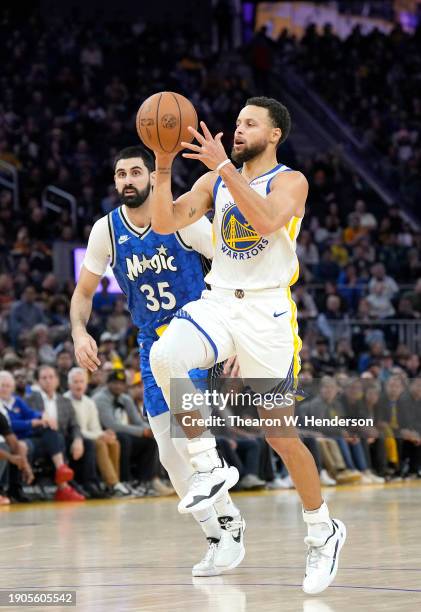 Stephen Curry of the Golden State Warriors drives towards the basket past Goga Bitadze of the Orlando Magic during the fourth quarter of an NBA...