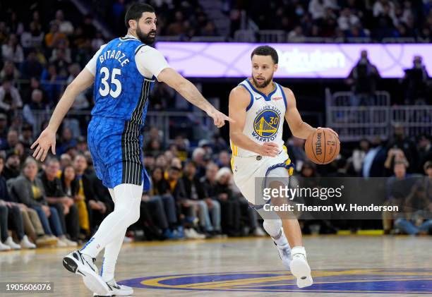 Stephen Curry of the Golden State Warriors drives towards the basket past Goga Bitadze of the Orlando Magic during the fourth quarter of an NBA...