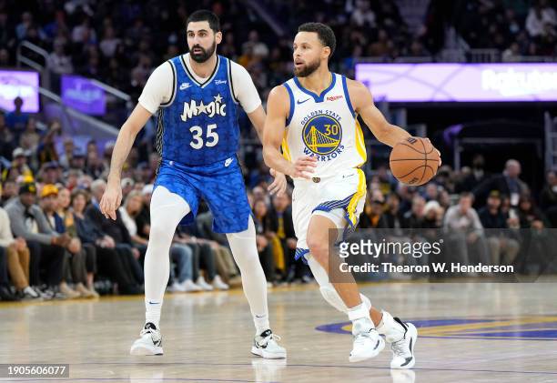 Stephen Curry of the Golden State Warriors drives towards the basket past Goga Bitadze of the Orlando Magic during the fourth quarter of an NBA...