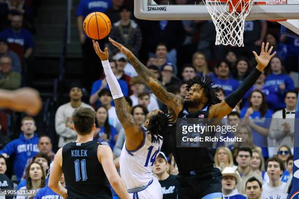 Dre Davis of the Seton Hall Pirates attempts a shot as David Joplin of the Marquette Golden Eagles defends during the first half of a game at...