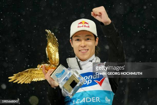 Four-Hills tournament's winner Japan's Ryoyu Kobayashi celebrates with the trophy after the fourth stage as part of the FIS Ski Jumping World Cup, in...