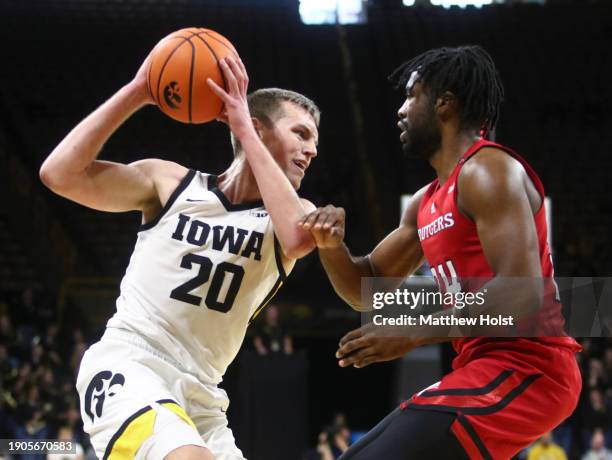 Forward Payton Sandfort of the Iowa Hawkeyes goes to the basket during the second half against guard Austin Williams of the Rutgers Scarlet Knights...