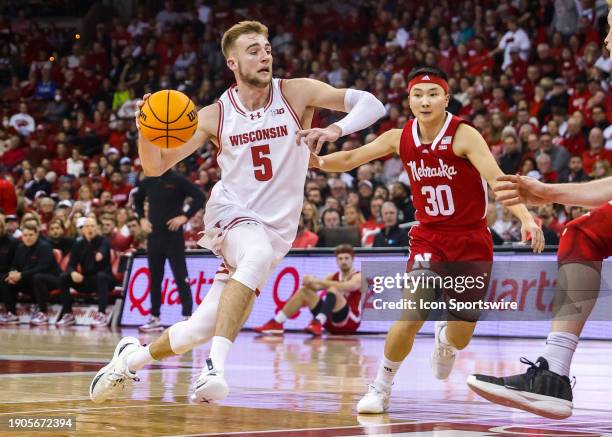 Wisconsin forward Tyler Wahl heads for the basket past Nebraska guard Keisei Tominaga during a college basketball game between the University of...