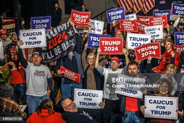 Supporters hold signs in front of TV cameras as they wait the arrival of former US President and Republican presidential hopeful Donald Trump speaks...