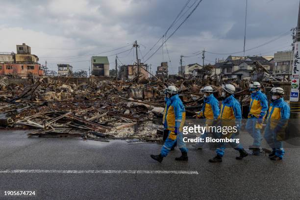 Police officers walk past a razed neighborhood in Wajima, Ishikawa Prefecture, Japan, on Saturday, Jan. 6, 2024. Japanese Prime Minister Fumio...