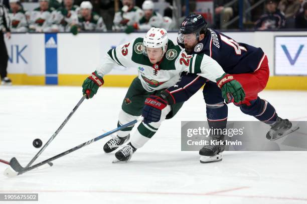 Marco Rossi of the Minnesota Wild and Erik Gudbranson of the Columbus Blue Jackets battle for control of the puck during the second period of the...