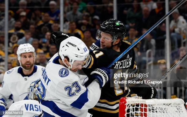 Trent Frederic of the Boston Bruins shoves Michael Eyssimont of the Tampa Bay Lightning during the third period at the TD Garden on January 6, 2024...