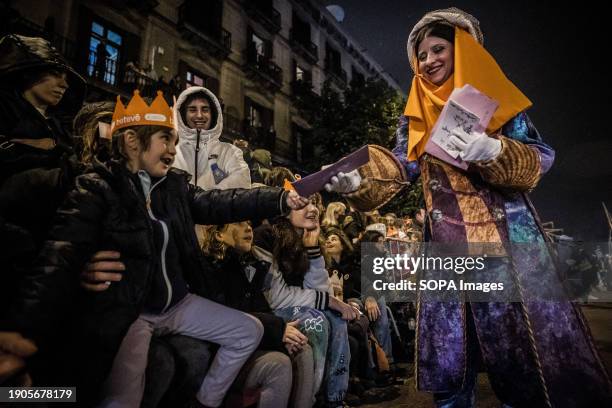 Child gives his gift letter to a mailwoman during the three Kings parade. Barcelona receives the Three Wise Men parade every year on the eve of...