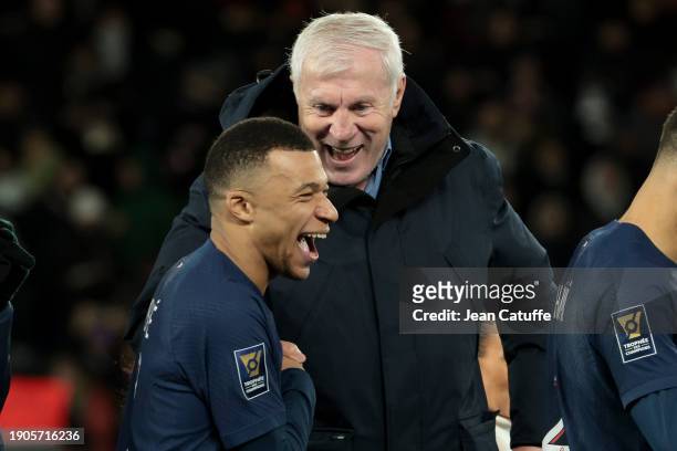 Trophy presenter Luis Fernandez jokes with Kylian Mbappe of PSG during the trophy ceremony following the Trophee des Champions between Paris...