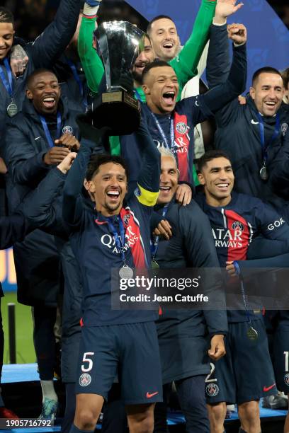 Captain of PSG Marquinhos - holding the trophy - along Ousmane Dembele, Kylian Mbappe, Keylor Navas, Achraf Hakimi and teammates celebrate during the...