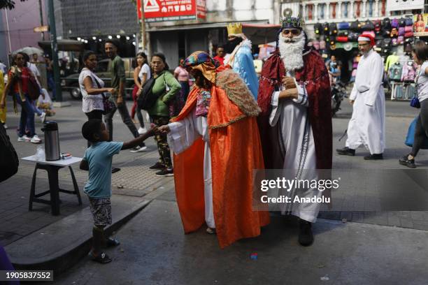 Man dressed as the Wizard King gives a gift to a child on the street in Caracas, Venezuela on January 6, 2024. Volunteers from the Alcangel Miguel...