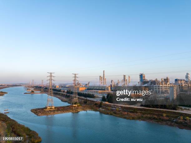 transmission poles next to the chemical plant by the river in the evening - 鉄塔 ストックフォトと画像