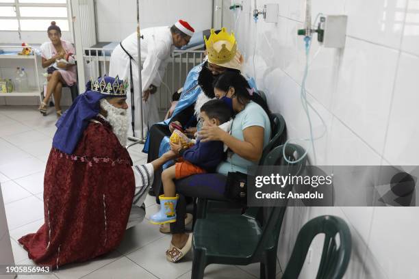 Man dressed as the Wizard King gives a gift to a child in the hospitalization area at a low-income hospital in Caracas, Venezuela on January 6, 2024....