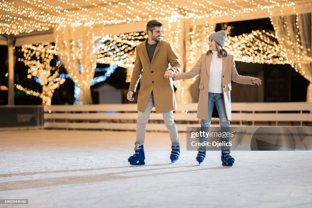 Happy couple having fun ice skating.