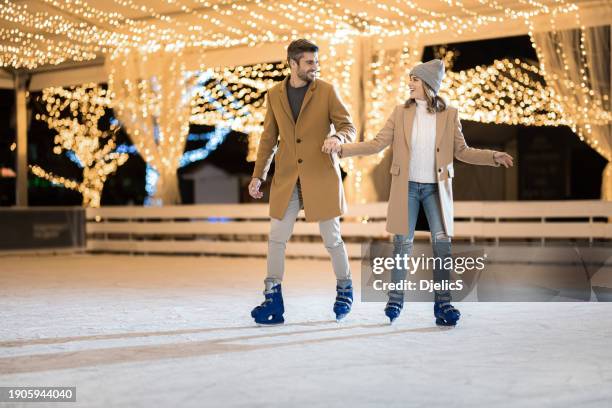 happy couple having fun ice skating. - patim de gelo imagens e fotografias de stock