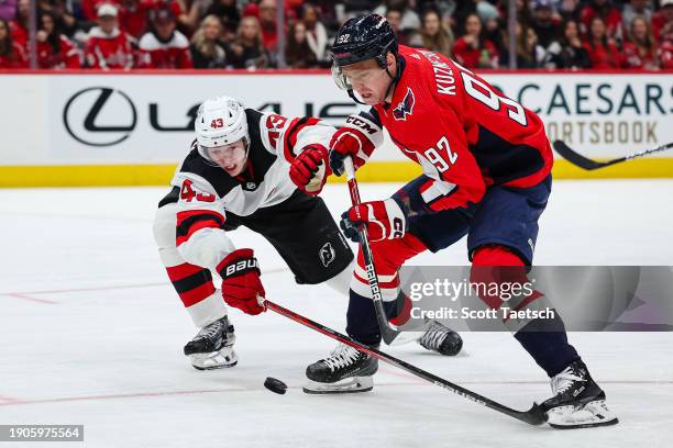 Evgeny Kuznetsov of the Washington Capitals and Luke Hughes of the New Jersey Devils battle for the puck during the second period of the game at...