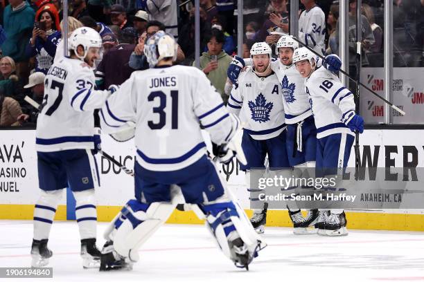 Timothy Liljegren, Martin Jones, Morgan Rielly and Mitchell Marner congratulate Auston Matthews of the Toronto Maple Leafs after his winning goal...