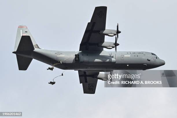 Military personnel jump from a US Air Force plane as they take part in a joint military drill and demonstration conducted by Japan's Ground...