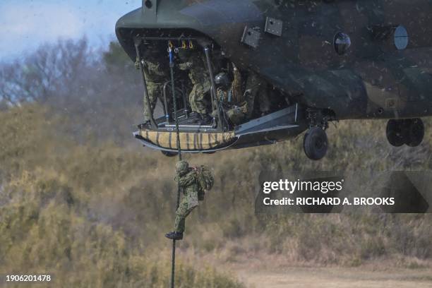 Japanese troops descend from a helicopter as they arrive to take part in a joint military drill and demonstration conducted by Japan's Ground...