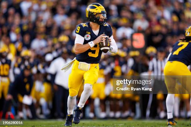 Quarterback J.J. McCarthy of the Michigan Wolverines rolls out and looks to throw a pass during the CFP Semifinal Rose Bowl Game against the Alabama...