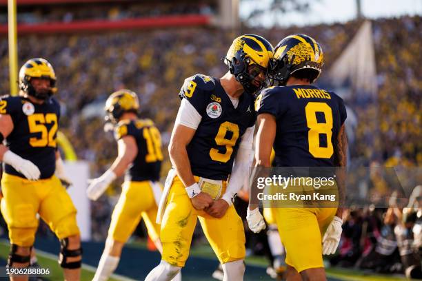 Quarterback J.J. McCarthy celebrates with wide receiver Tyler Morris of the Michigan Wolverines after scoring a touchdown during the CFP Semifinal...