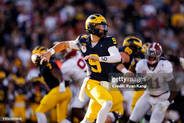 Quarterback J.J. McCarthy of the Michigan Wolverines rolls out and looks to throw a pass during the CFP Semifinal Rose Bowl Game against the Alabama...