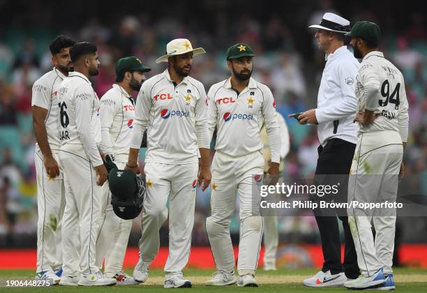 Umpire Michael Gough with Pakistan players as play was called off for bad light during day two of the Men's Third Test Match in the series between...