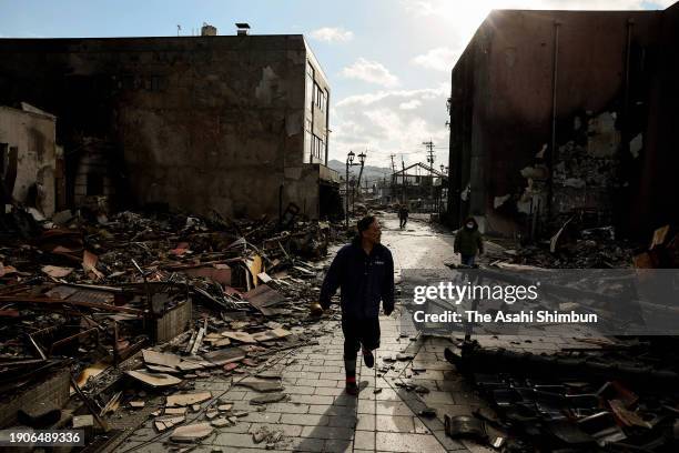 Man walks in the rubble at Asaichi Yokocho district where approximately 200 buildings had been burnt down three days after multiple strong...