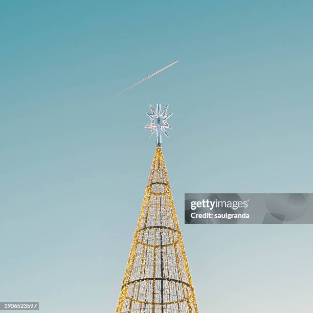 detail of led lights of christmas tree and an airplane with contrails - ornamentado stock-fotos und bilder