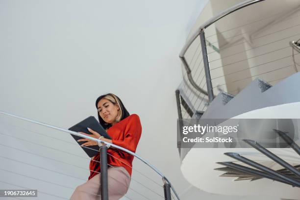 businesswoman walking down a staircase - three quarter length stock pictures, royalty-free photos & images