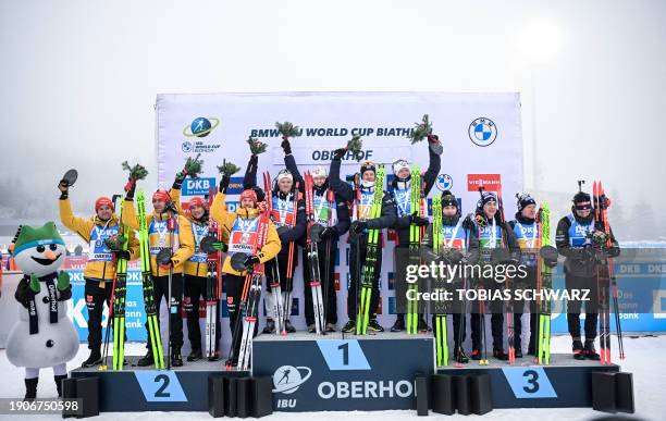 Second placed team of Germany, winner team of Norway and third placed team of Italy celebrate on the podium of the men's 4x 7,5km relay event of the...