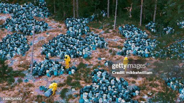 the stark reality of outdoor dumpsites and their guardians in hazmat gear - miss world stock pictures, royalty-free photos & images